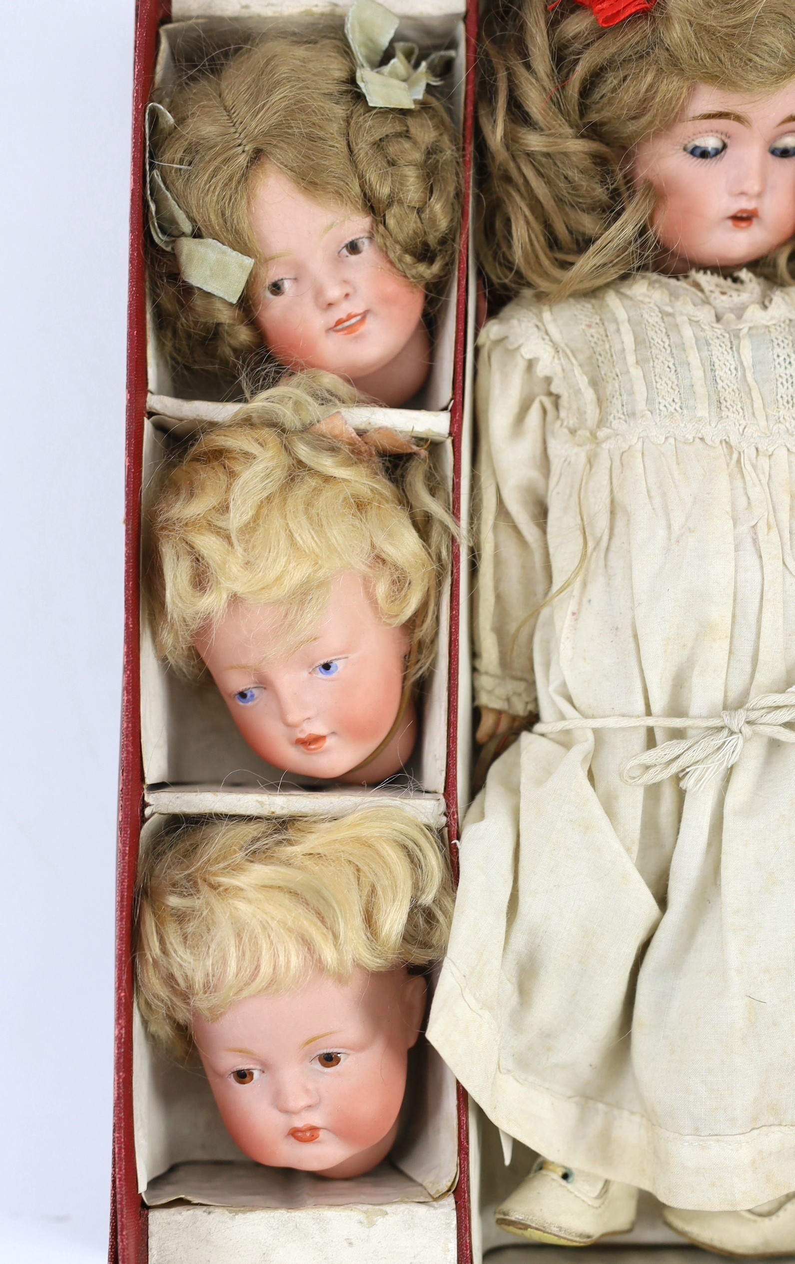 A rare J. D. Kestner bisque character doll, with three interchangeable character heads, German, circa 1910, overall 28cm high, retaining original instructions of how to change heads and the original box